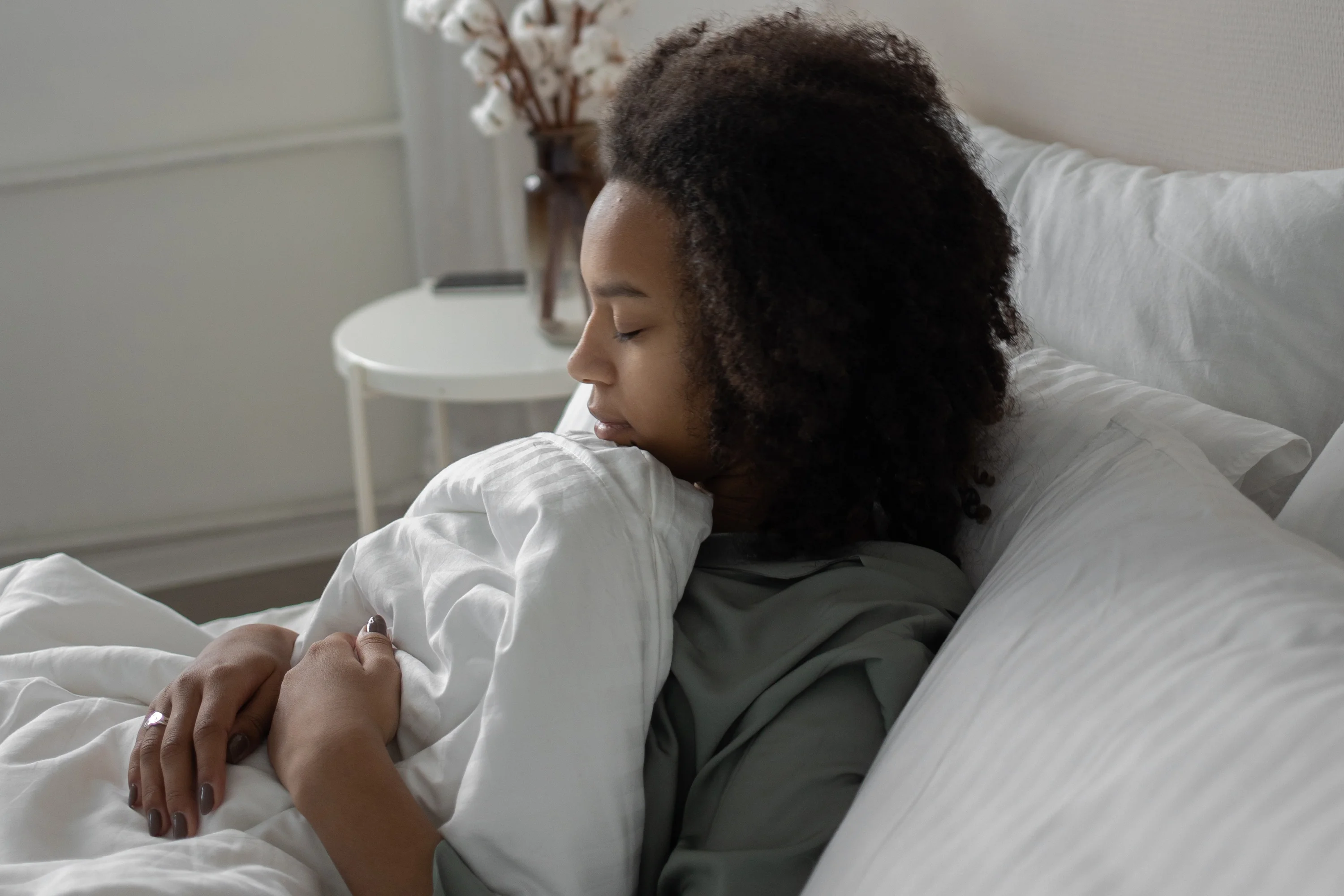 woman sitting up in bed with eyes closed